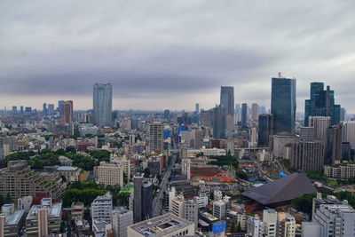 Aerial view of buildings in city against sky