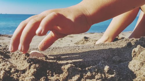 Close-up of hands on sand