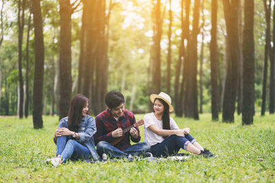 Young couple sitting on land in forest