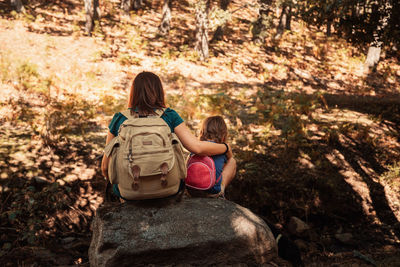 Rear view of a girl sitting on rock