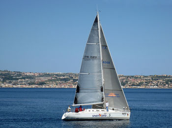 Sailboat sailing on sea against clear sky