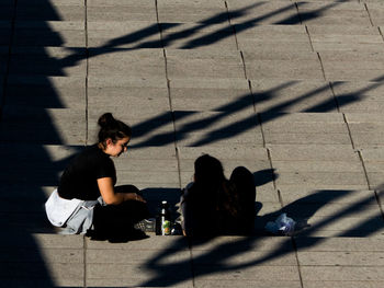 High angle view of people sitting on floor in city