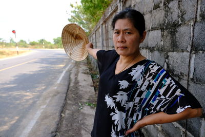 Mature woman wearing casuals while standing against wall