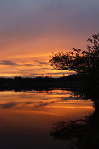 Scenic view of lake against romantic sky at sunset