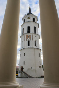 Bell tower of vilnius cathedral against sky seen through columns