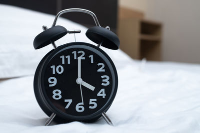 Close-up of clock on bed