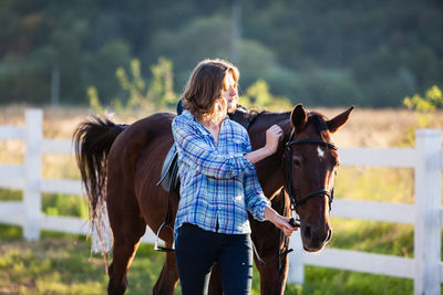 Woman stroking horse in farm