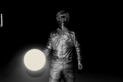 Man standing against illuminated light bulb