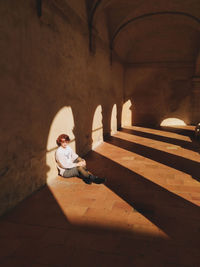 Person sitting in corridor of building