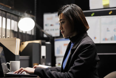 Side view of young businesswoman working at office
