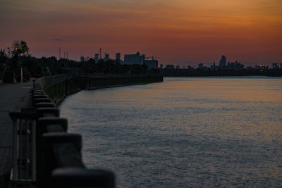 View of city at waterfront during sunset