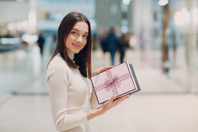 Portrait of smiling young woman holding umbrella