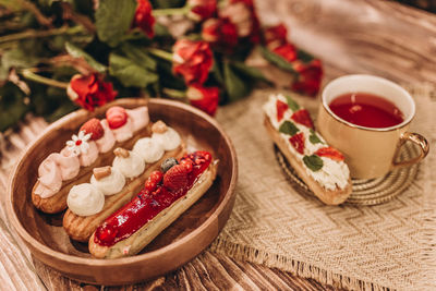 Plate with cakes and a cup of tea on a wooden table