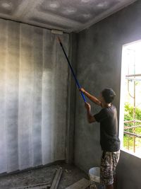 Full length of woman standing against wall at home