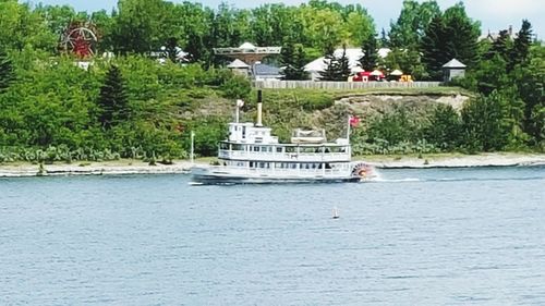 Boat sailing on river by trees