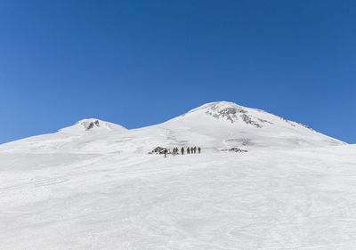 Scenic view of snowcapped mountains against clear blue sky