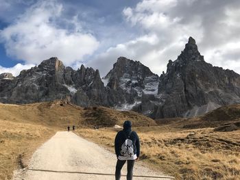 Rear view of woman standing against mountain range 