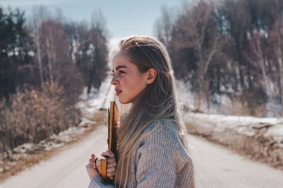 Portrait of beautiful young woman standing in snow