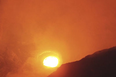 Scenic view of silhouette mountain against orange sky