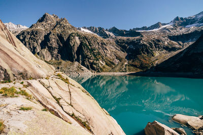 Panoramic view of lake and mountains against clear blue sky