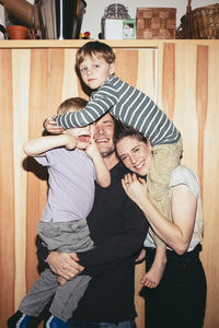 Playful family having fun with each other while standing at home