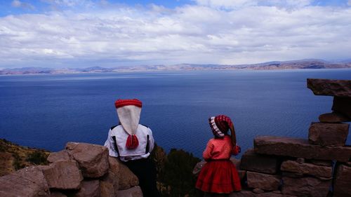 Rear view of woman looking at sea against sky