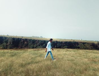 Full length of boy on field against clear sky