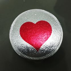 Close-up of heart shape on table against black background