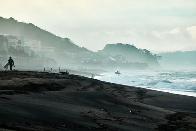 People on beach against sky