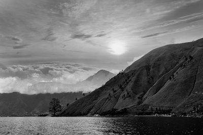 Scenic view of lake by mountains against sky