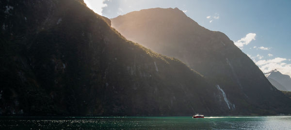 Scenic view of sea and mountains against sky