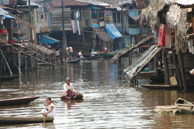 People on boats in canal along buildings