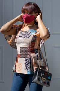 Portrait of woman wearing mask standing outdoors