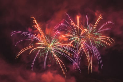 Wonderful couple of red fireworks on the feast of the patron saint of vittorio veneto, italy 