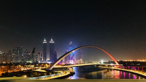 Bridge over river in city at night