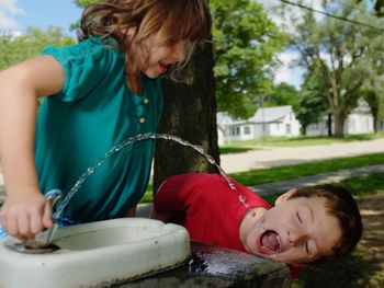 Friends drinking water of fountain