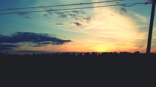 Silhouette of landscape against cloudy sky at sunset