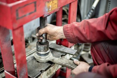 Midsection of man working on metal