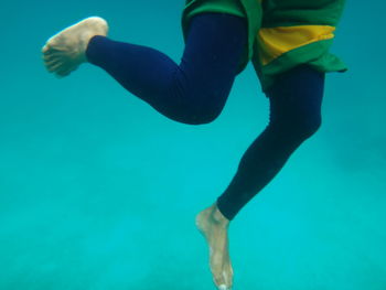 Low section of man swimming in sea