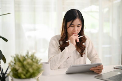 Young woman using mobile phone at home