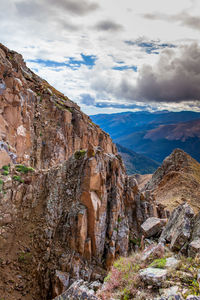 View of rock formations on landscape against cloudy sky