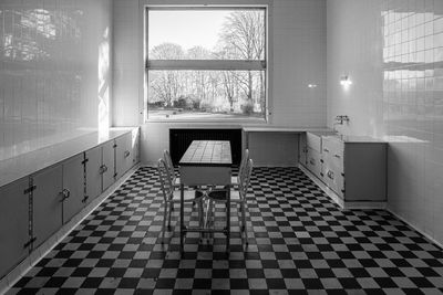 Empty chairs and tables in tiled floor