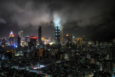 Panoramic view over taipei 101 and surrounding buildings at night during a rain storm. 