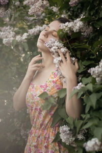 Midsection of woman standing by flowering plants