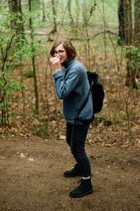 Side view of woman standing in forest