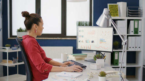 Businesswoman using desktop pc at office