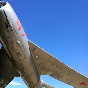 Airplane wing against clear blue sky