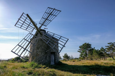 Traditional windmill on field against sky