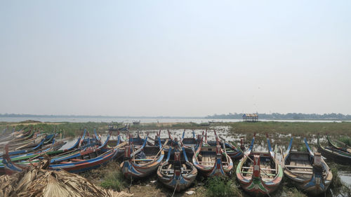 Boats moored on land against clear sky