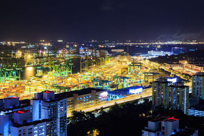 High angle view of illuminated buildings against sky at night